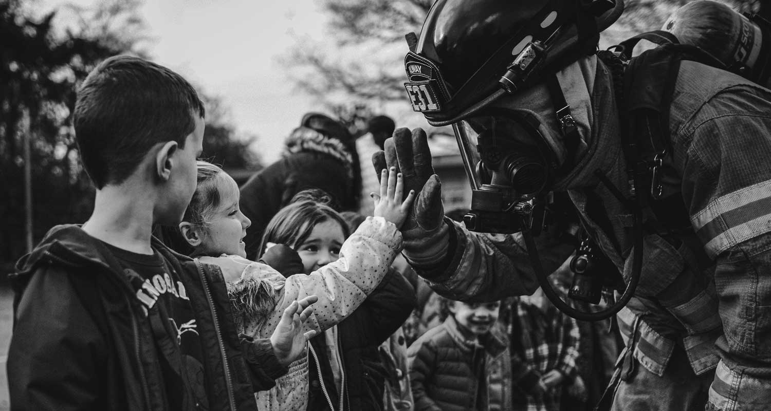 High five firefighter to child