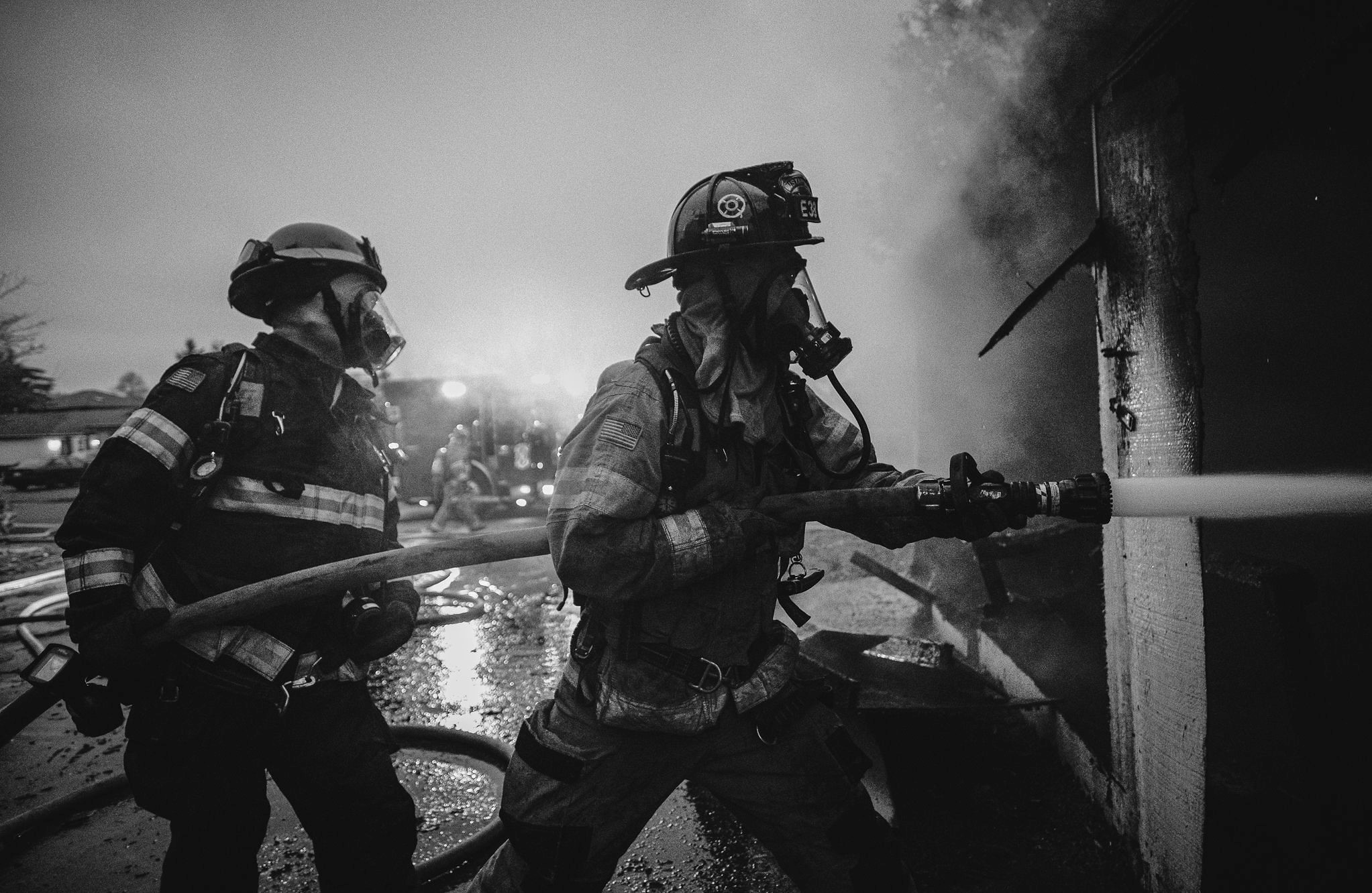 Two firemen from the Valley Regional Fire Authority fighting a fire in a black and white photo.