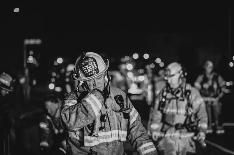 A black and white photo of a firefighter from the Valley Regional Fire Authority at night.