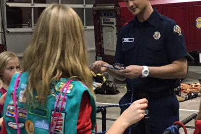 A boy scout helping a girl scout at Valley Regional Fire Authority.