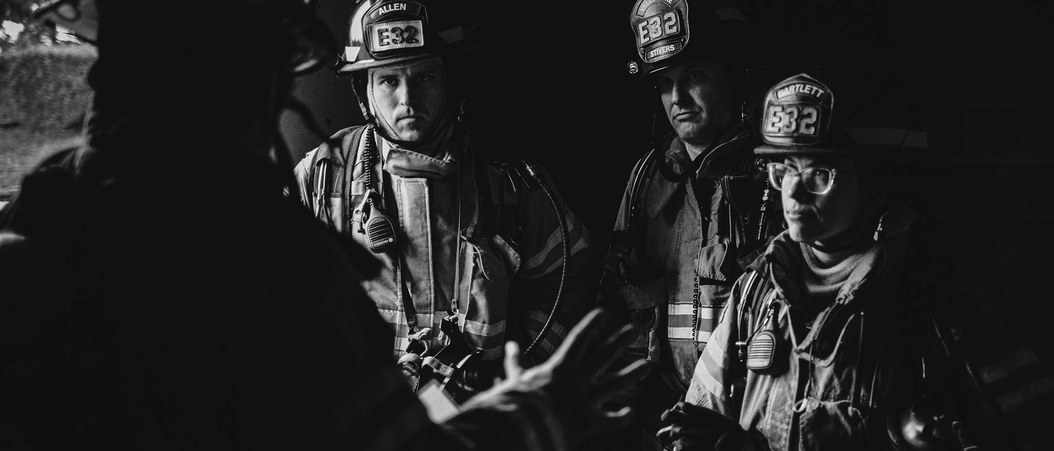 Valley Regional Fire Authority firefighters gathered in a dark room discussing their service.