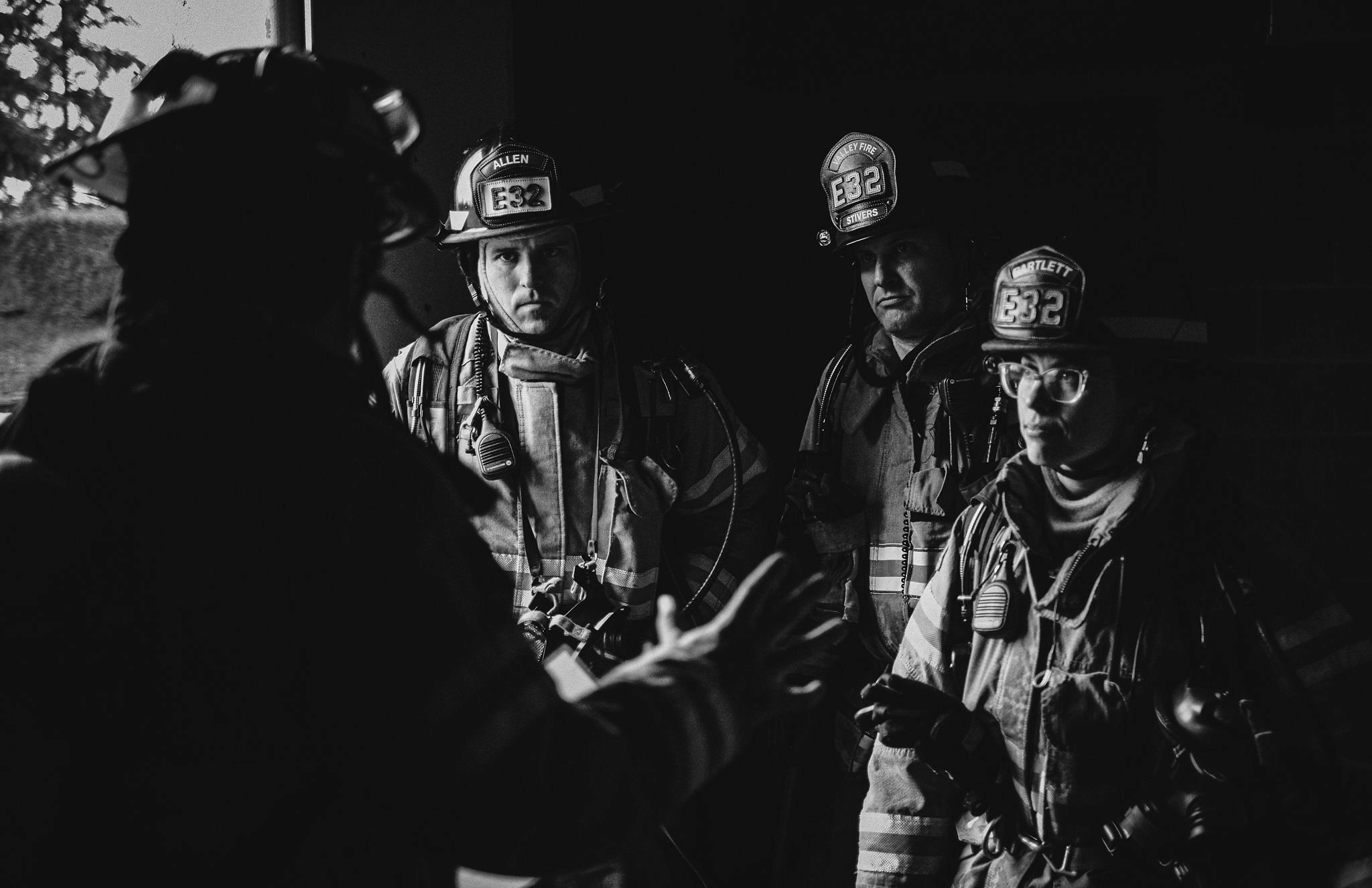 Valley Regional Fire Authority firefighters gathered in a dark room discussing their service.