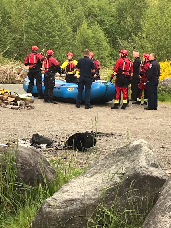 A group of firefighters from Valley Regional Fire Authority standing around a raft in the woods, providing their service.