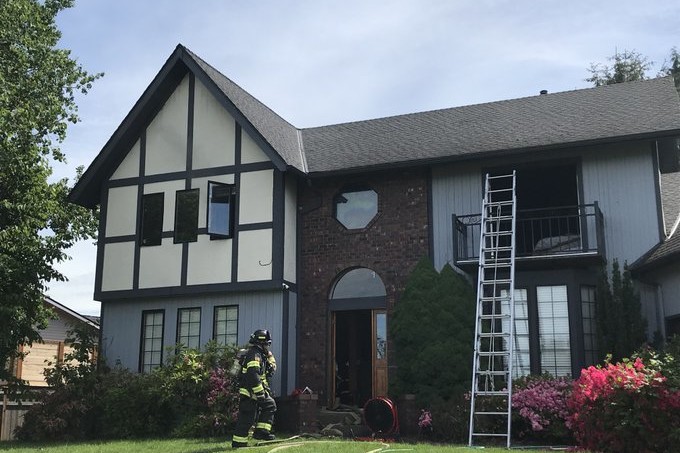 A firefighter from the fire department is providing rescue service to put out a fire in a house.