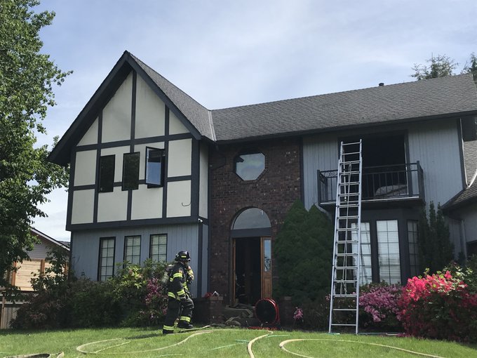 A firefighter from the fire department is providing rescue service to put out a fire in a house.