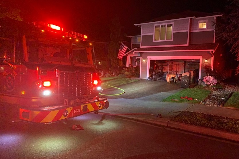 A fire truck from Valley Regional Fire Authority is parked in front of a house at night, manned by a firefighter from the Fire Department.