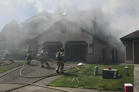 A Valley Regional Fire Authority firefighter is rescuing inhabitants from a house fire.