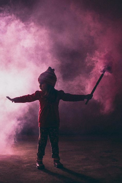 Child holding a smoking firework