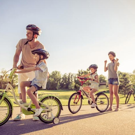 Family of four on bikes wearing helmets