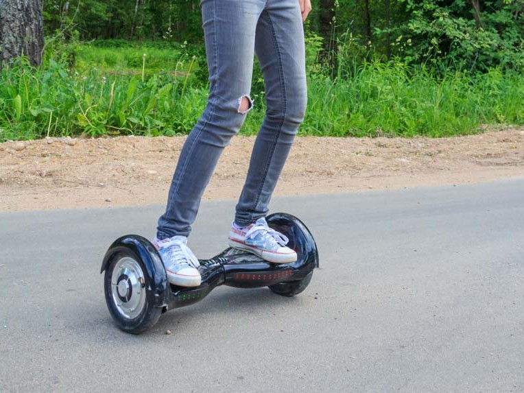 A person riding a hoverboard on a road, attracting the attention of the fire department.