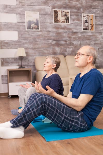 Old couple doing breathing exercise