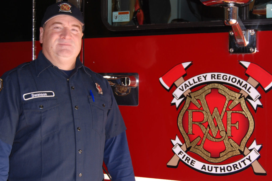 A firefighter standing in front of a fire truck.