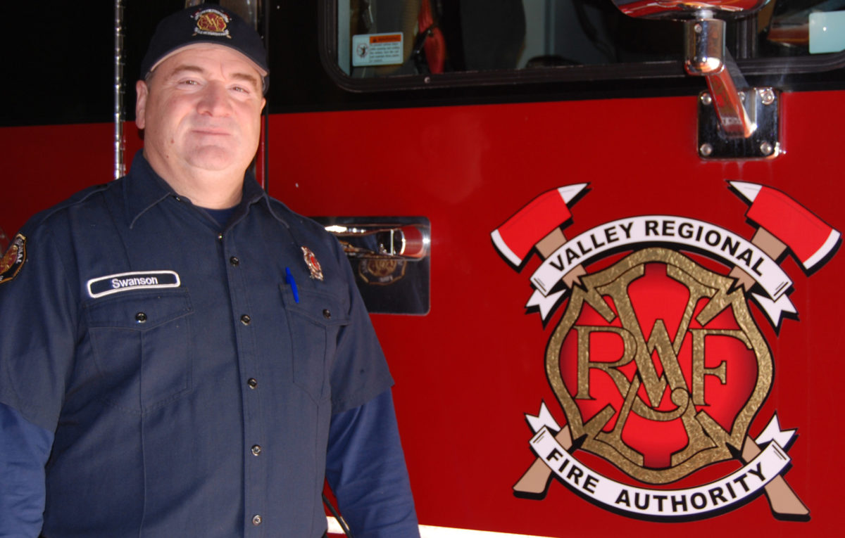 A firefighter standing in front of a fire truck.