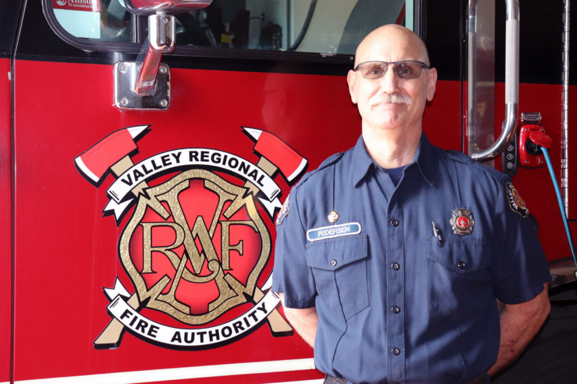 A firefighter standing in front of a fire truck.