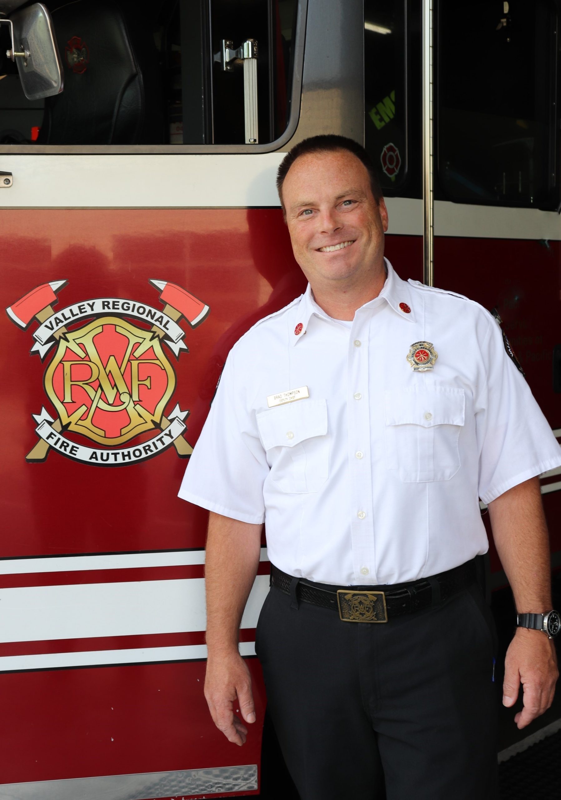 A man standing in front of a fire truck from Valley Regional Fire Authority.