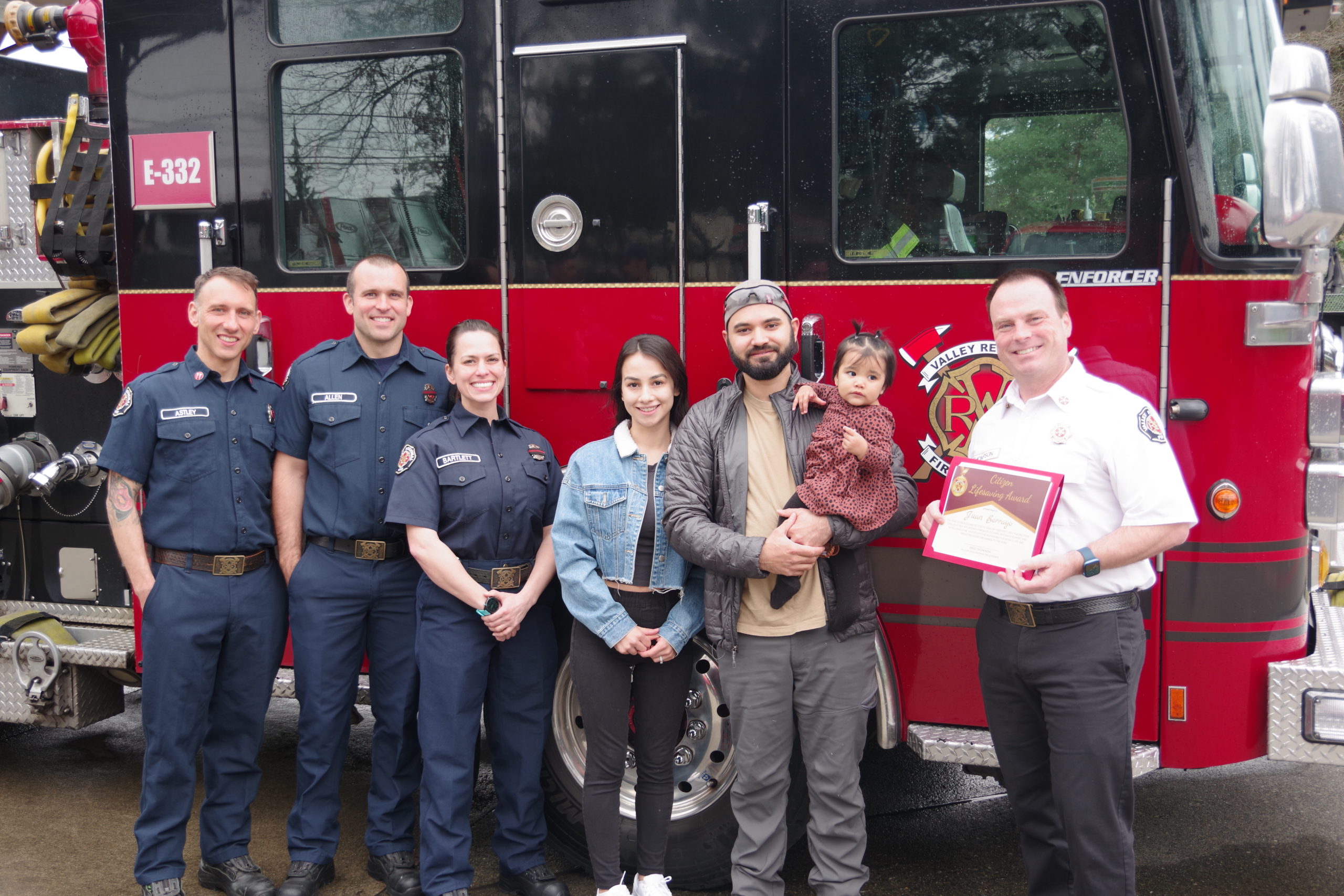 Family with fire fighters in front of engine