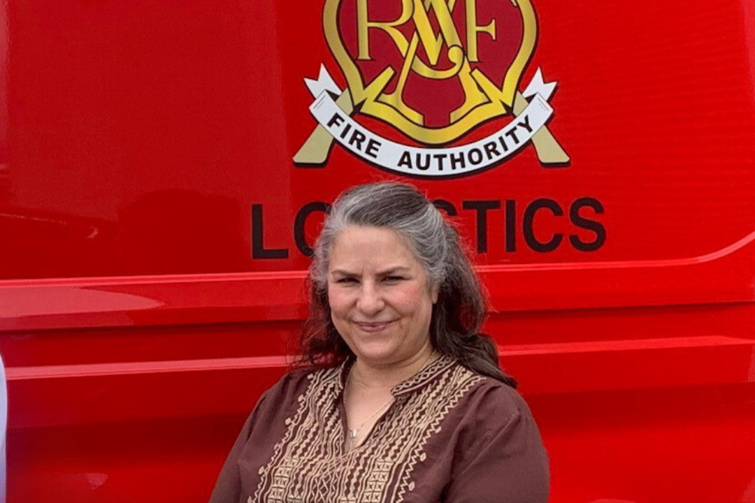 Two women standing in front of a red fire truck belonging to the Valley Regional Fire Authority.