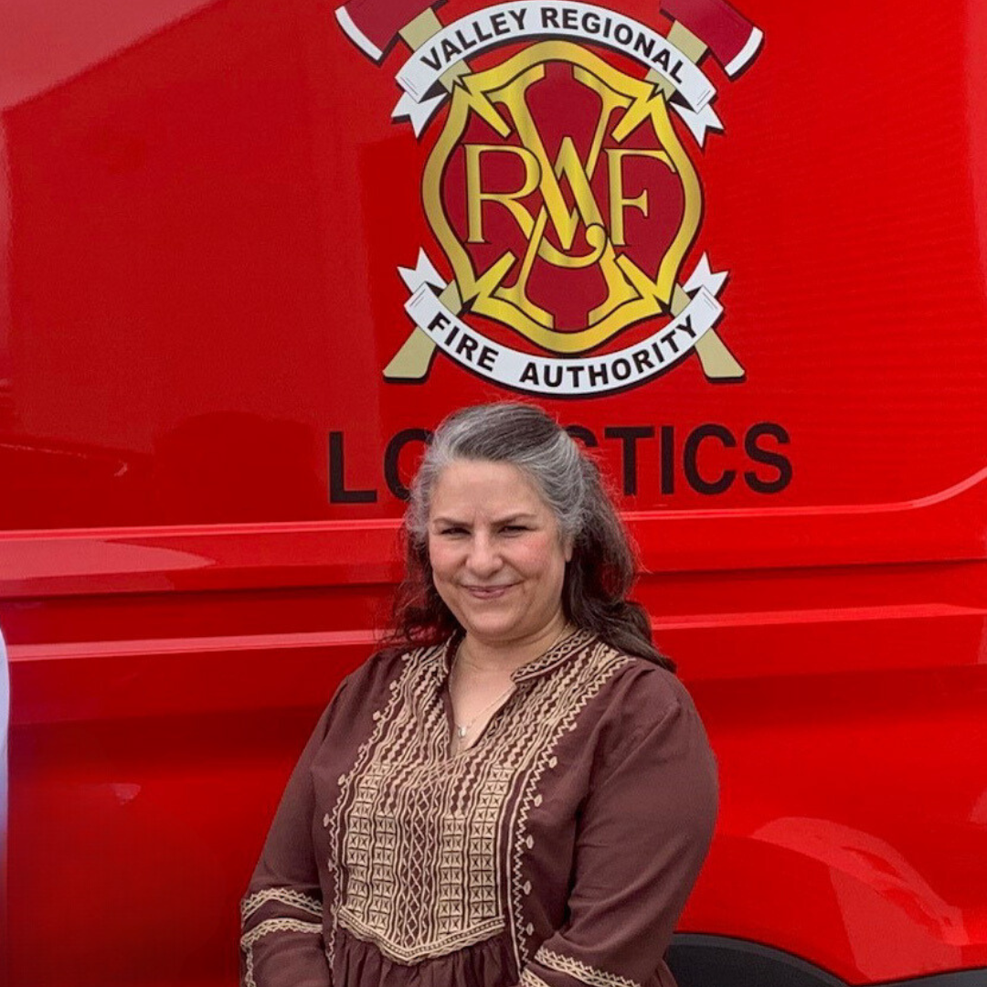 Two women standing in front of a red fire truck belonging to the Valley Regional Fire Authority.