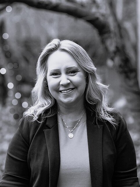 A black and white photo of a woman smiling.