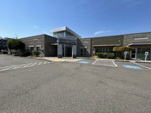 Single-story medical office building with "Cascade Orthopaedics" sign, accessible parking, and clear blue sky—showcasing progress from design to construction in our latest Capital Facilities Plan milestones.