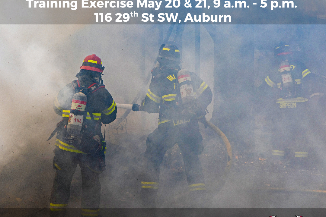 Three firefighters in full gear work in thick smoke during Live Fire Training, part of the King County Fire Training event. Smoke warning and caution about calling 9-1-1 are displayed, with event details in Auburn, WA.